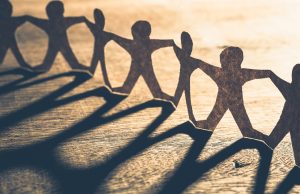 Human chain paper with light and shadow on wood table